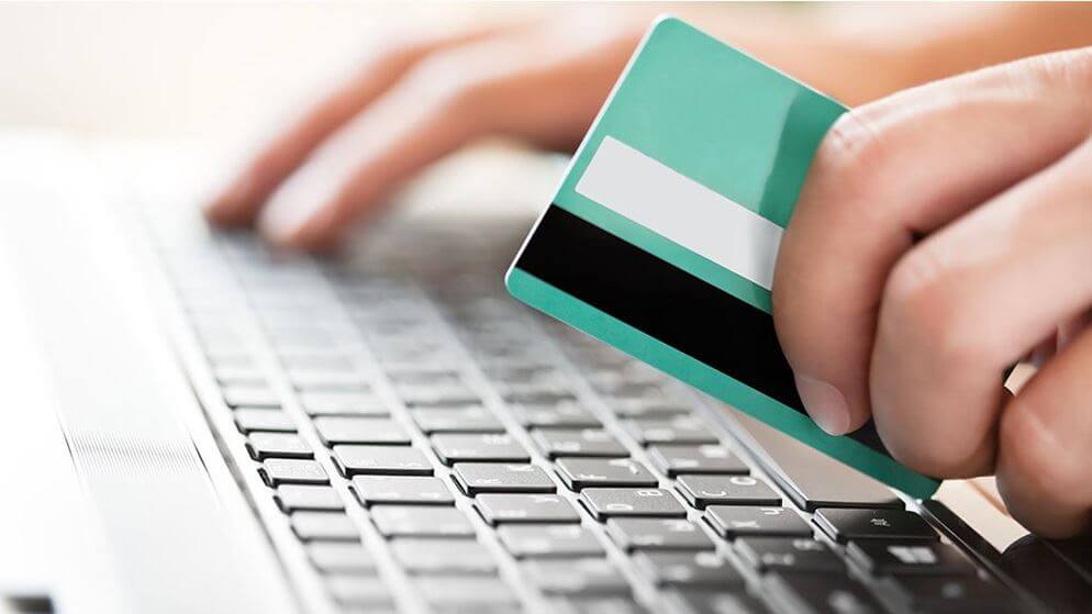 A person shopping online with their credit card.